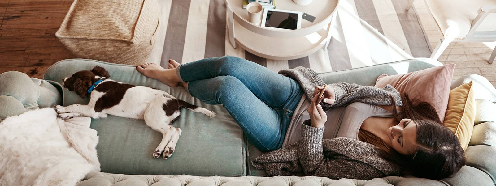 Woman lying on a sofa on her phone.